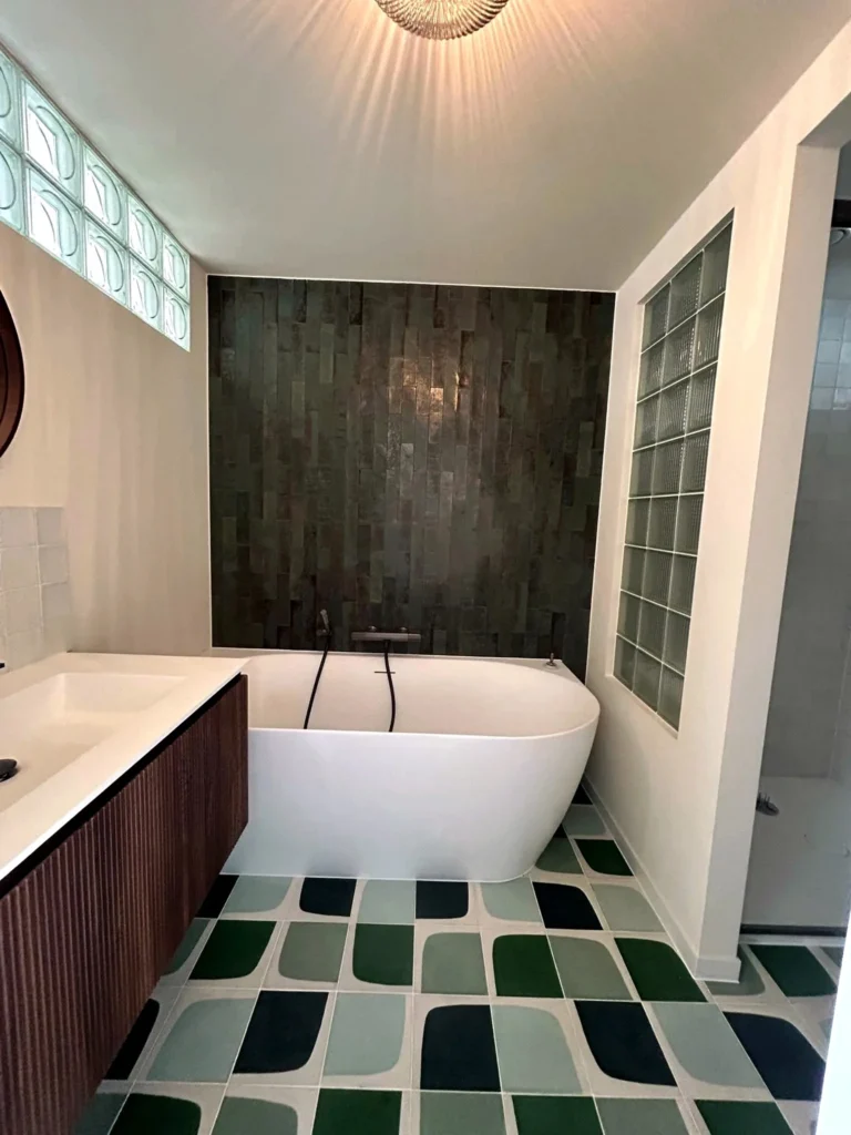 Retro Botanic — badkamer renovatie met glazen bouwstenen ligbad en wastafelmeubel met lamellen